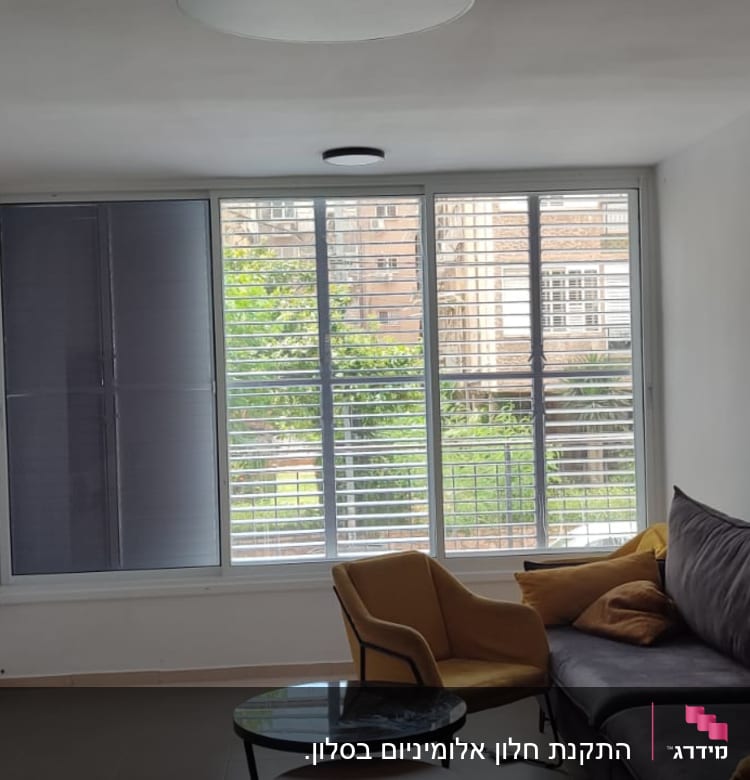 חלון עם תריסי אלומיניום בסלון מואר